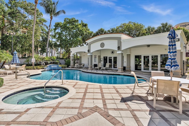 view of pool featuring a hot tub, a patio area, and french doors