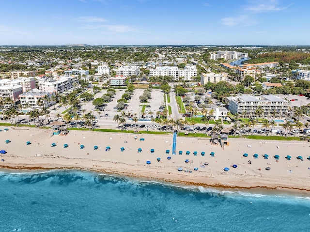 birds eye view of property featuring a beach view and a water view