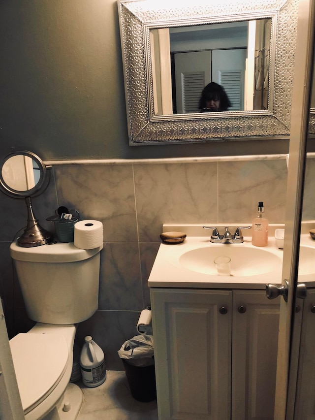 bathroom featuring tasteful backsplash, tile walls, toilet, and large vanity