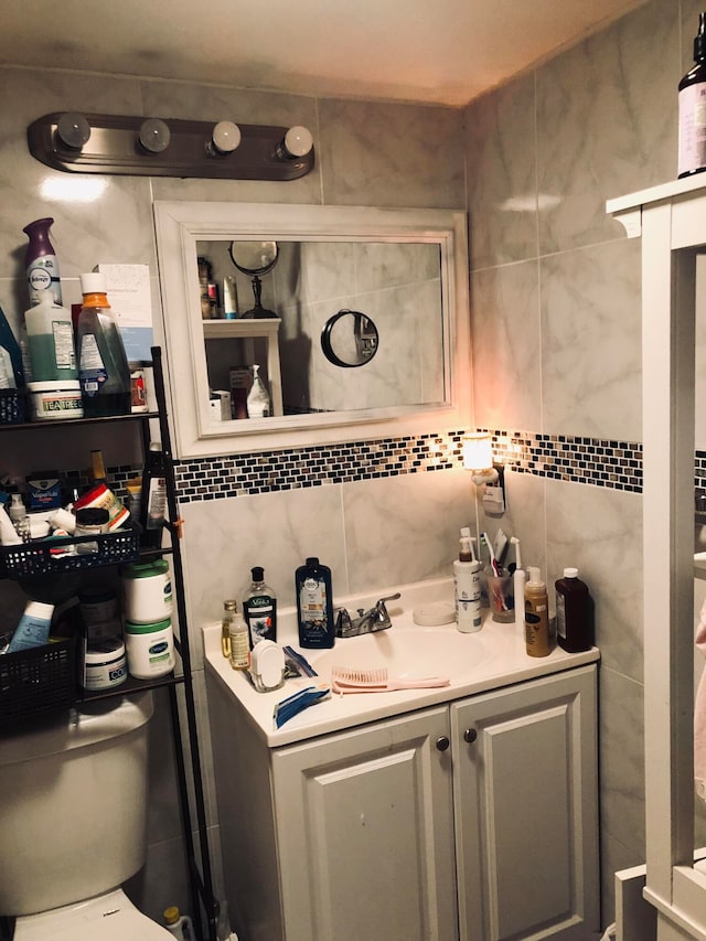 bathroom featuring tile walls, vanity, and toilet