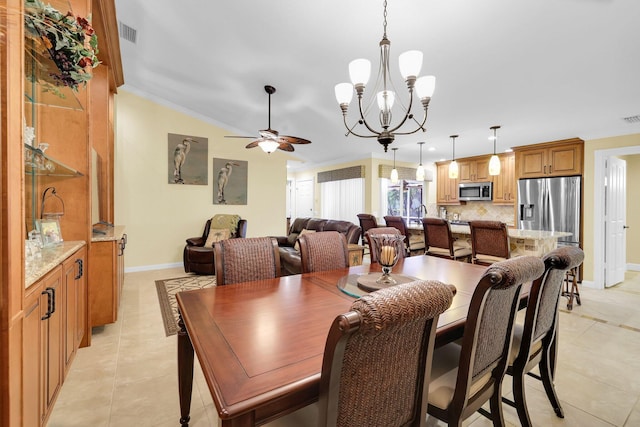 tiled dining room with ceiling fan with notable chandelier and crown molding