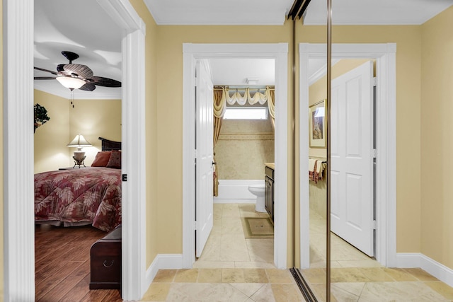 hallway with light hardwood / wood-style flooring and ornamental molding