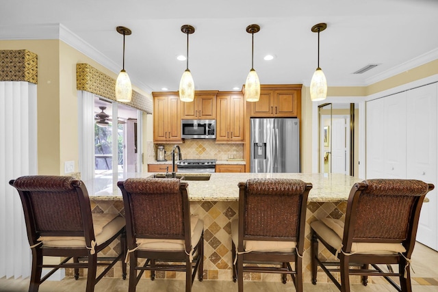 kitchen featuring light stone countertops, ornamental molding, stainless steel appliances, and hanging light fixtures