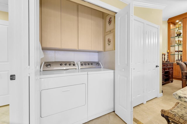 clothes washing area featuring cabinets, light tile patterned floors, and separate washer and dryer