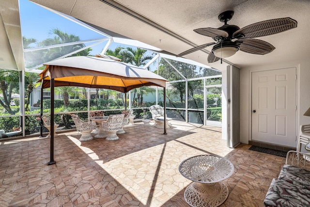 view of patio with a gazebo, ceiling fan, and a lanai