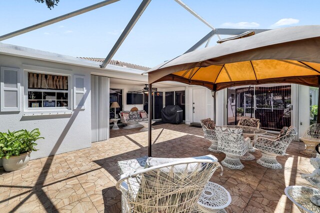 view of patio / terrace featuring a gazebo, ceiling fan, a lanai, and a grill