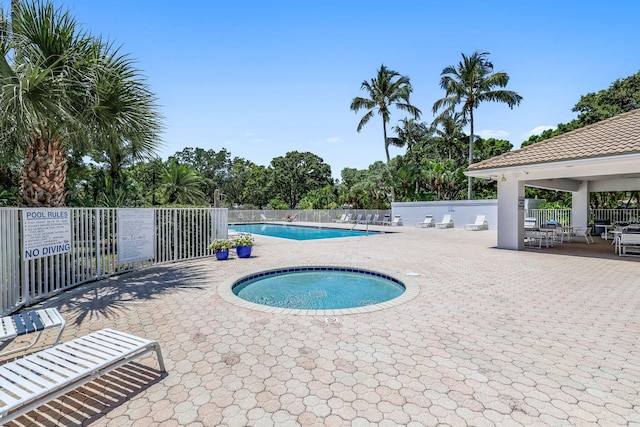 view of swimming pool with a patio area and a hot tub