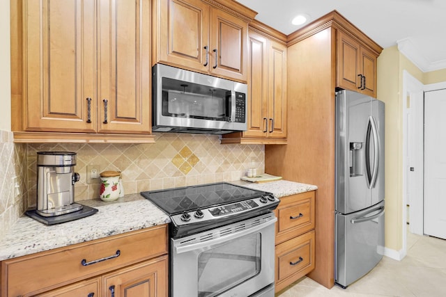 kitchen with light stone countertops, backsplash, crown molding, light tile patterned floors, and appliances with stainless steel finishes