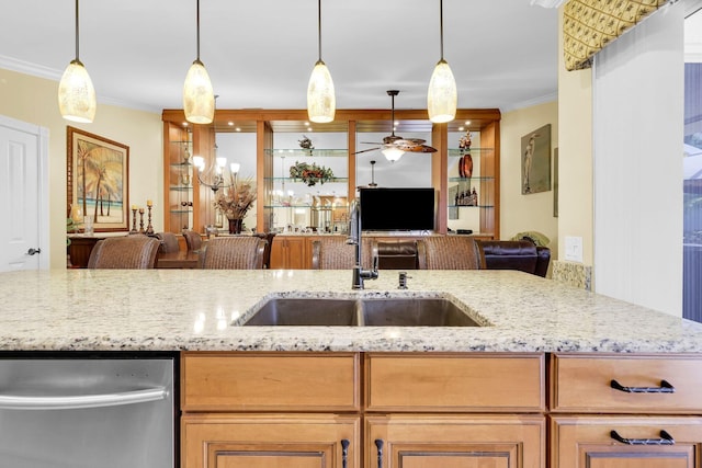 kitchen with pendant lighting, light stone counters, crown molding, and sink