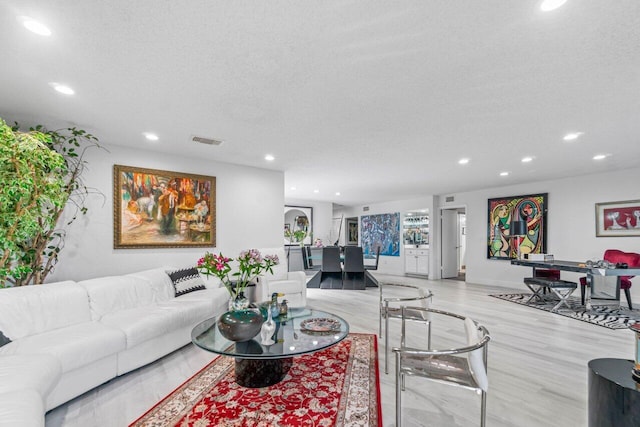 living room featuring a textured ceiling and light wood-type flooring