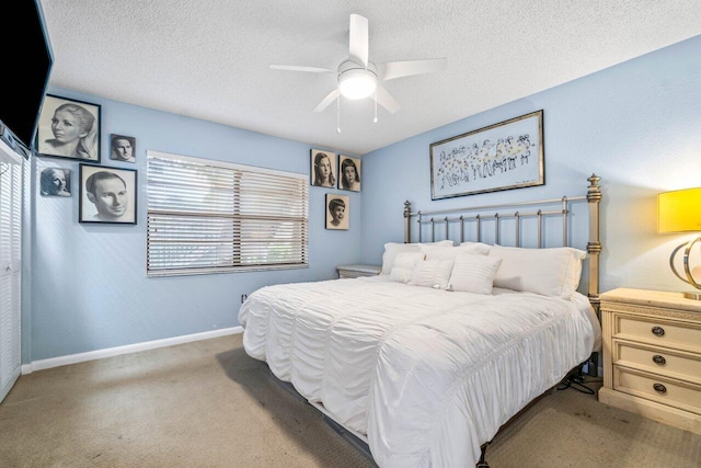 bedroom featuring ceiling fan, a textured ceiling, and light carpet