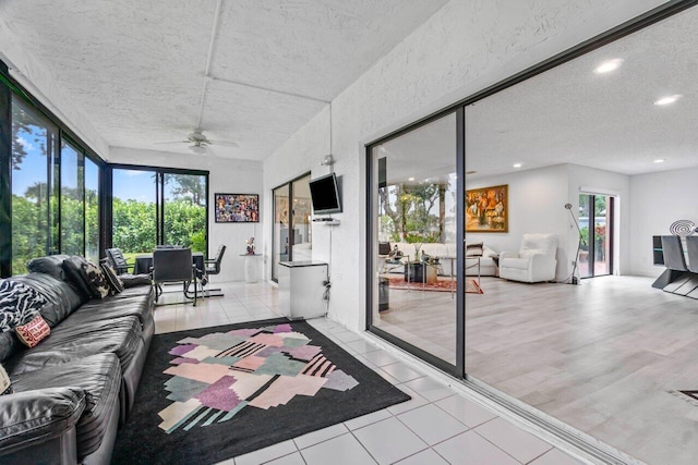 sunroom featuring ceiling fan