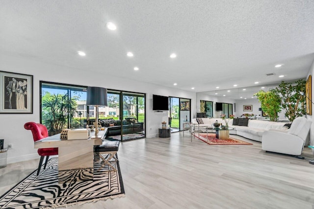 living room with light wood-type flooring and a textured ceiling