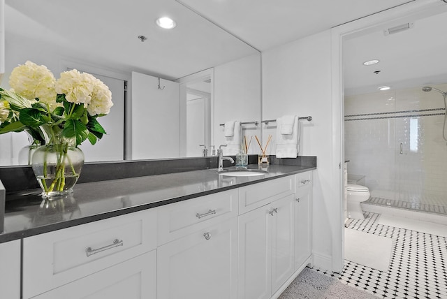 bathroom with tile patterned floors, an enclosed shower, vanity, and toilet