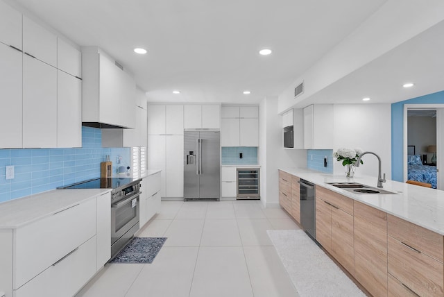 kitchen featuring wine cooler, backsplash, white cabinetry, appliances with stainless steel finishes, and sink