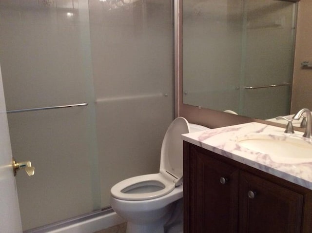 bathroom with a shower with shower door, oversized vanity, and toilet