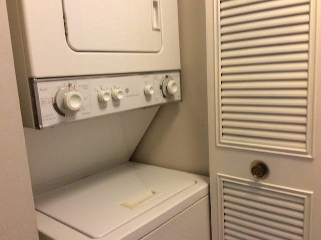 clothes washing area featuring stacked washer / dryer