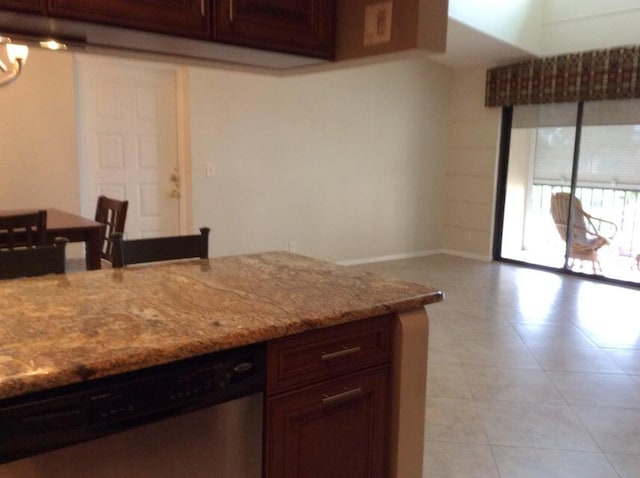 kitchen with dishwasher, light stone countertops, and light tile floors