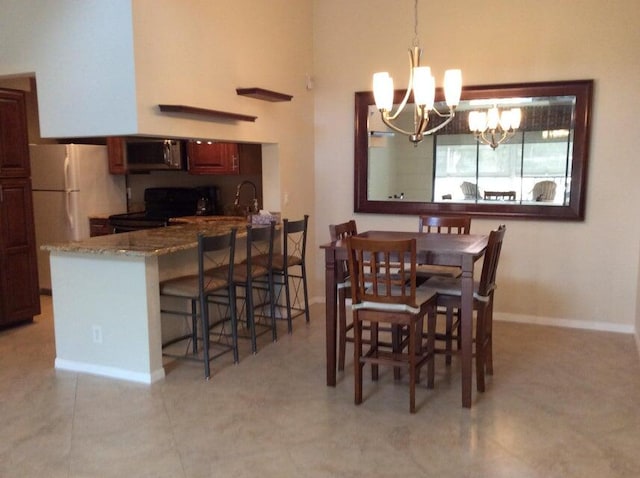 dining area with a chandelier and light tile flooring