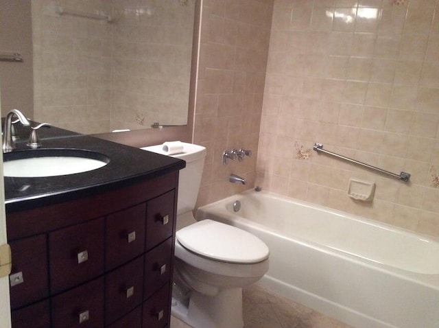 full bathroom with tile flooring, tiled shower / bath, vanity, and toilet