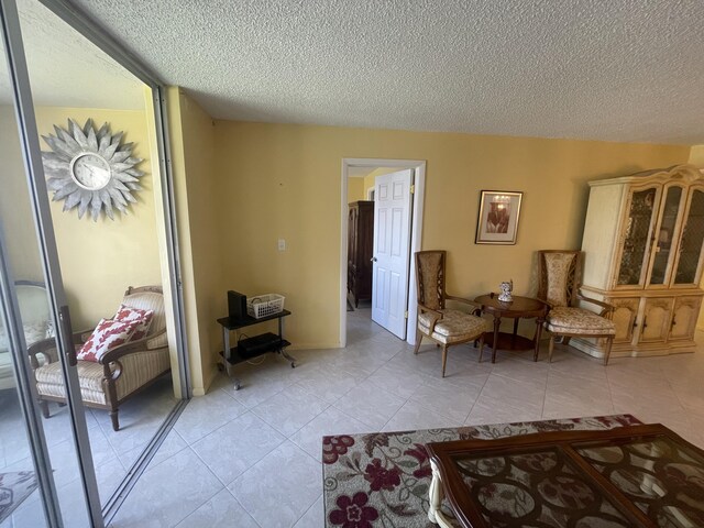 sitting room featuring a textured ceiling and light tile flooring