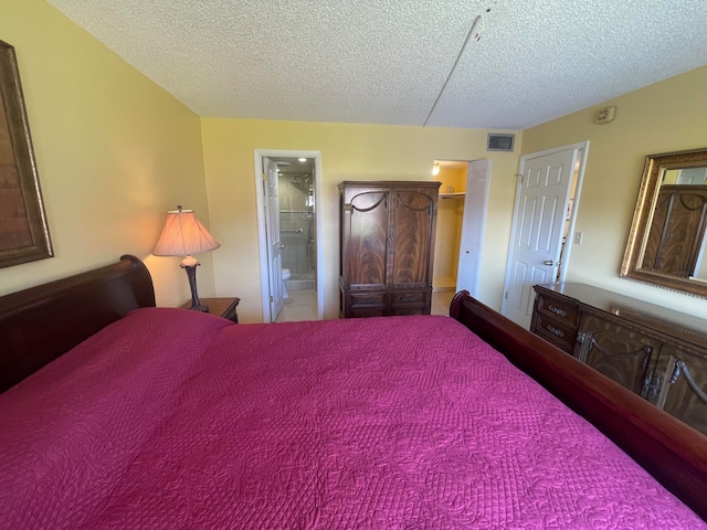 bedroom featuring a textured ceiling and ensuite bath