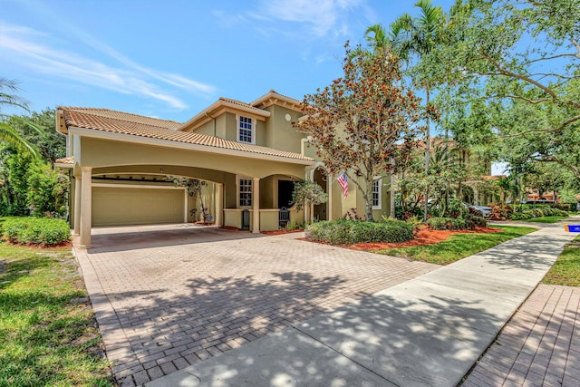 mediterranean / spanish home featuring a garage and a carport