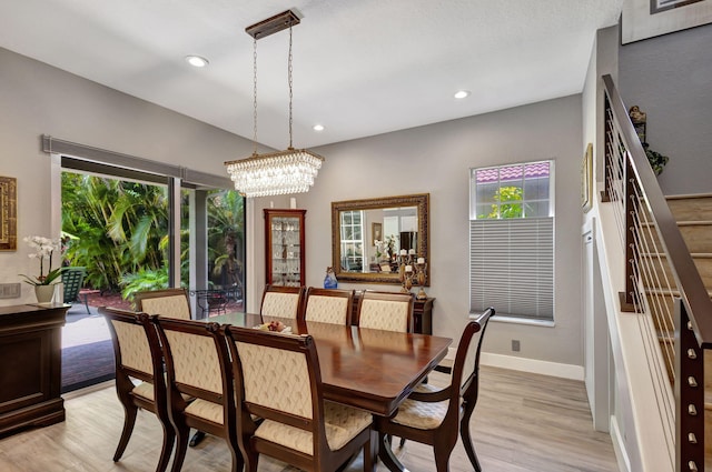 dining area with an inviting chandelier and light hardwood / wood-style flooring