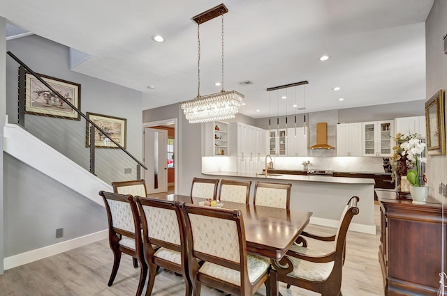 dining room featuring light hardwood / wood-style flooring, sink, and a chandelier