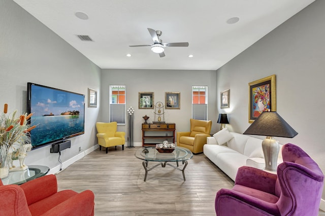 living room with plenty of natural light, ceiling fan, and light hardwood / wood-style flooring