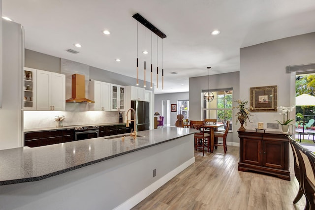 kitchen featuring white cabinets, a wealth of natural light, sink, and pendant lighting