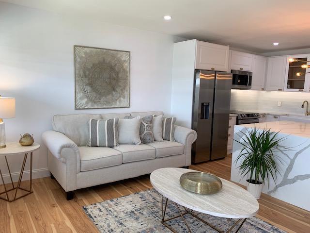 living room featuring sink and light hardwood / wood-style flooring