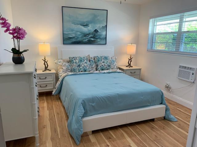 bedroom featuring a wall mounted air conditioner and light wood-type flooring