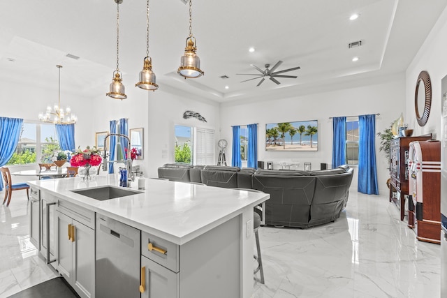 kitchen featuring sink, hanging light fixtures, a kitchen breakfast bar, stainless steel dishwasher, and a center island with sink