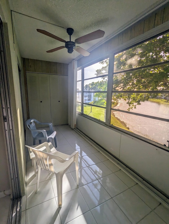 unfurnished sunroom with ceiling fan