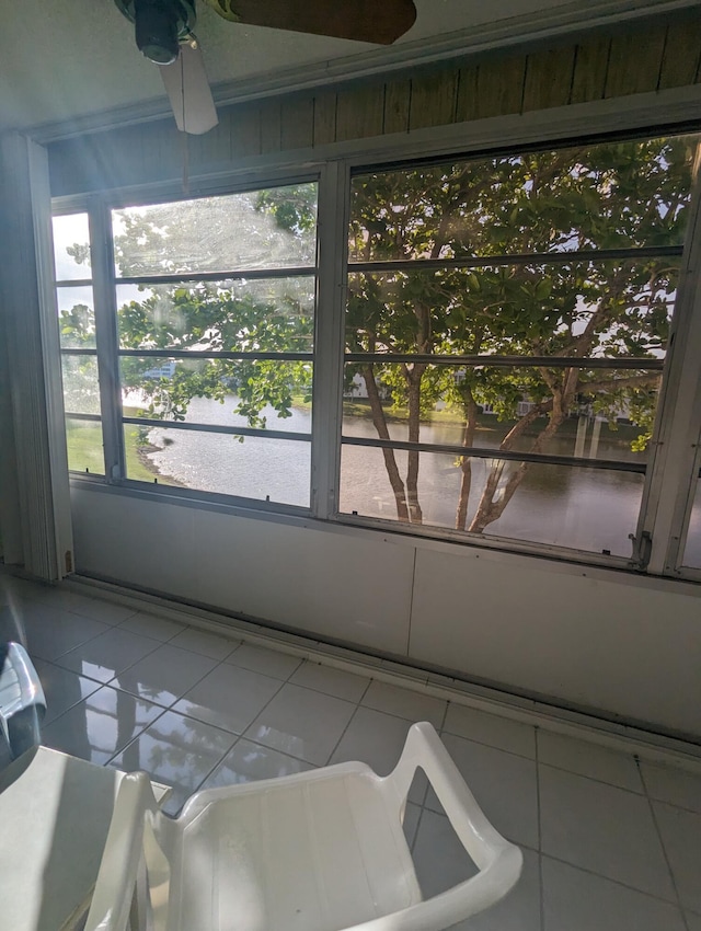 sunroom featuring a water view