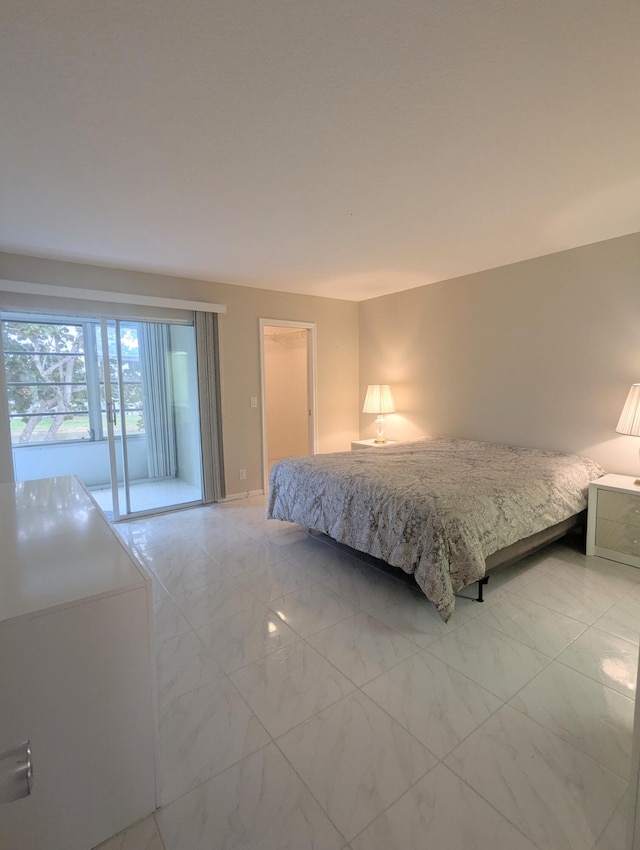 bedroom with marble finish floor and access to outside