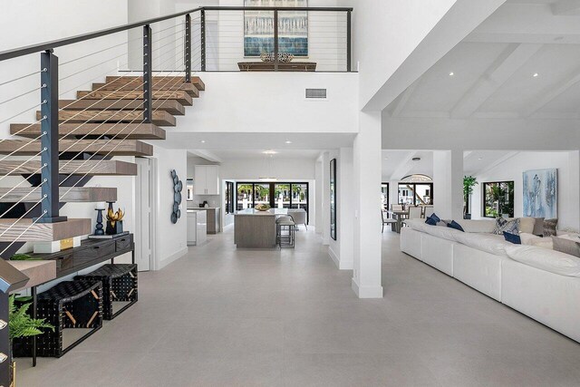 interior space with high vaulted ceiling and beam ceiling