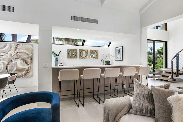 interior space with bar area and lofted ceiling with skylight