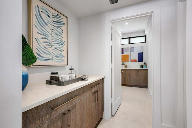 bar with light stone countertops and light tile flooring