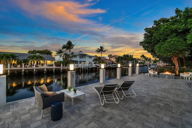 patio terrace at dusk with an outdoor living space and a water view