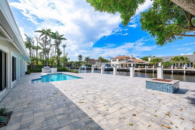 view of swimming pool featuring a patio and a water view