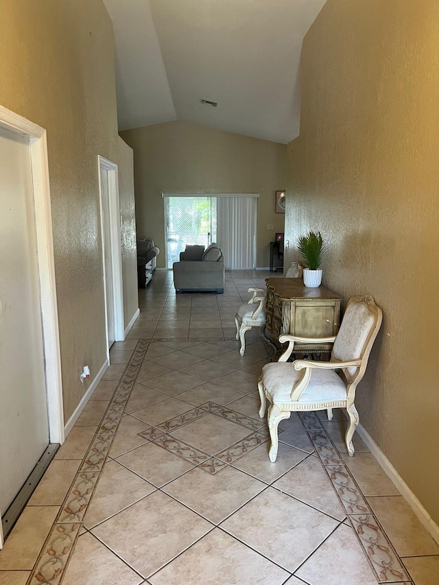 hall with tile floors and lofted ceiling