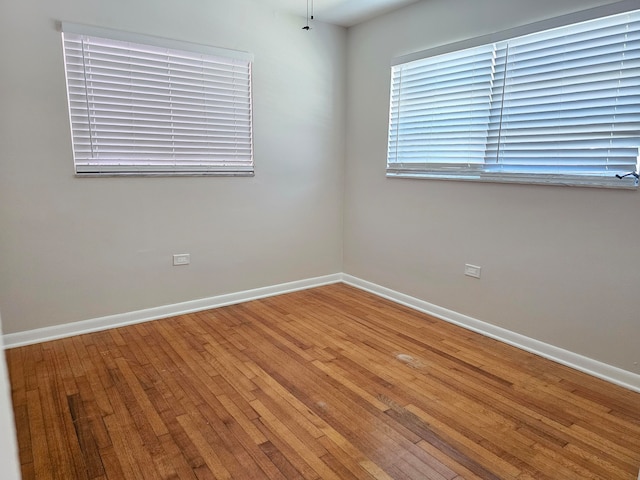 unfurnished room with hardwood / wood-style flooring