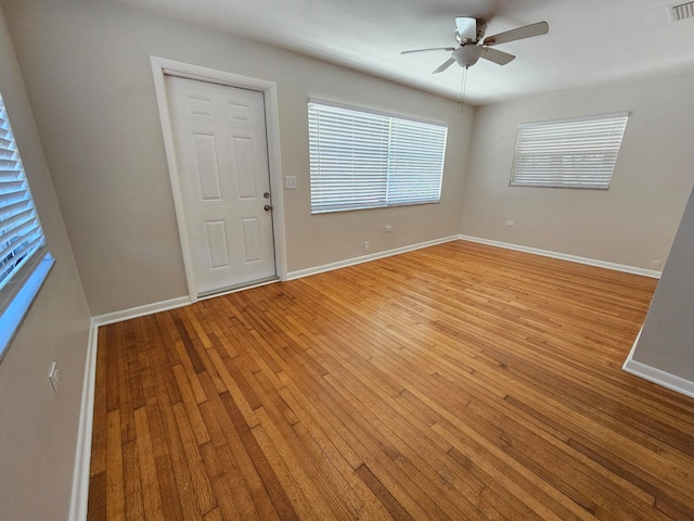 empty room with hardwood / wood-style flooring and ceiling fan