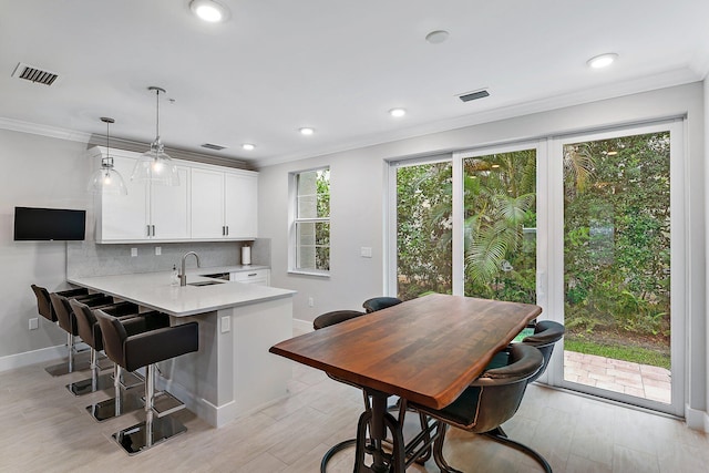 kitchen with white cabinets, kitchen peninsula, sink, and a wealth of natural light