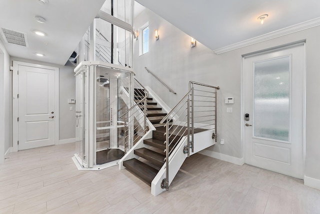 foyer featuring light wood-type flooring and ornamental molding