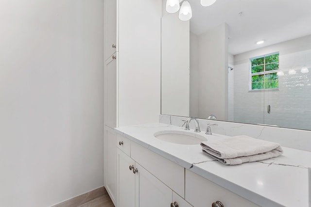 bathroom featuring wood-type flooring, vanity, and an enclosed shower