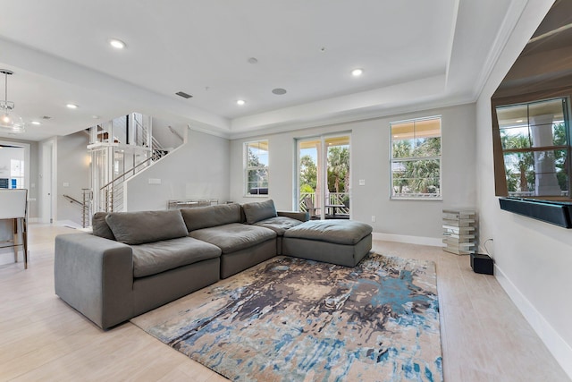 living room featuring light hardwood / wood-style floors and a raised ceiling