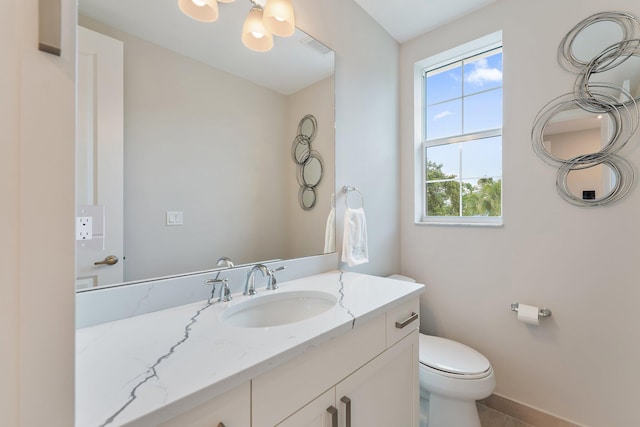 bathroom featuring tile patterned flooring, vanity, and toilet